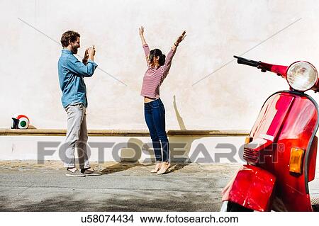 Young man photographing girlfriend on smartphone, Florence, Italy View Large Photo Image Picture - Young man photographing girlfriend on smartphone, Florence, Italy. Fotosearch