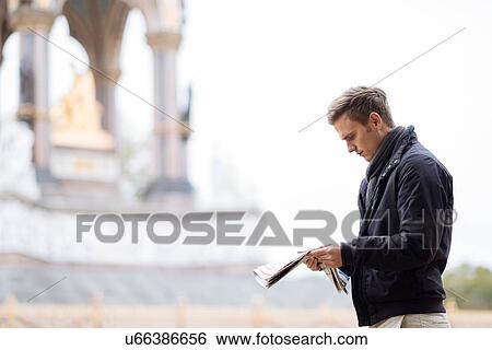 Young man reading newspaper in front of Albert Memorial, London, England, UK View Large Photo Image Stock Photograph - Young man reading newspaper in front of Albert Memorial, London, England, UK. Fotosearch