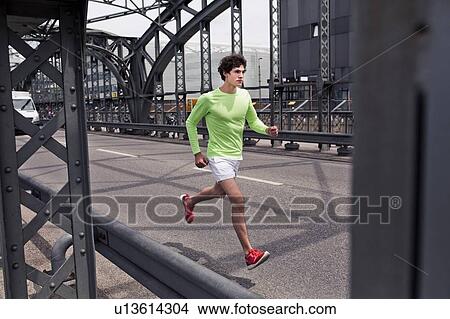Young man running across urban bridge View Large Photo Image Picture - Young man running across urban bridge. Fotosearch