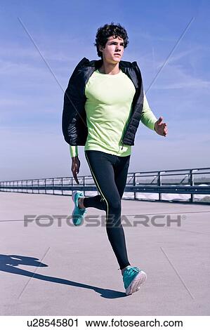 Stock Image - Young man running in city. Fotosearch