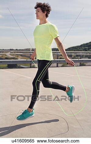 Young man training with skipping ropes in city View Large Photo Image Stock Photography - Young man training with skipping ropes in city. Fotosearch
