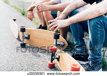 Young men sitting with skateboards View Large Photo Image Stock Image - Young men sitting with skateboards. Fotosearch