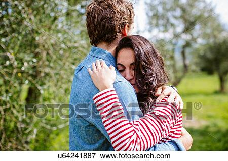 Stock Photo - Young romantic couple hugging in olive grove, Florence, Italy. Fotosearch
