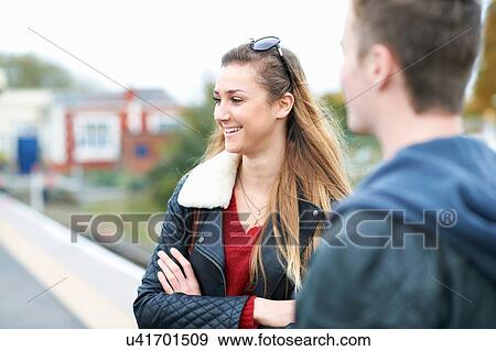 Young woman and young man standing on railway platform View Large Photo Image Stock Photo - Young woman and young man standing on railway platform. Fotosearch