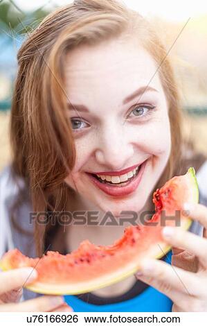 Stock Photograph - Young woman eating watermelon. Fotosearch