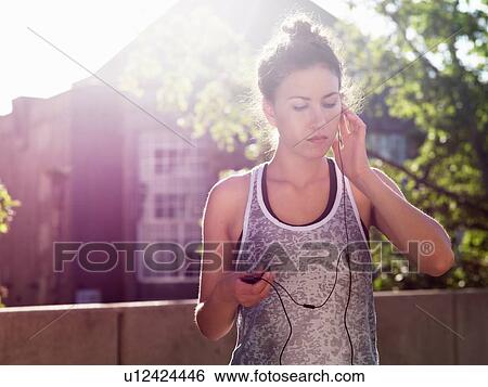 Young woman listening with earphones View Large Photo Image Stock Photograph - Young woman listening with earphones. Fotosearch