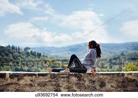 Young woman looking out from wall in Florence hills, Italy View Large Photo Image Picture - Young woman looking out from wall in Florence hills, Italy. Fotosearch