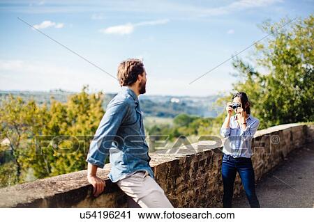 Stock Image - Young woman photographing boyfriend in Florence hills, Italy. Fotosearch