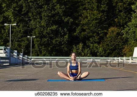 Young woman practicing yoga lotus pose in urban parking lot View Large Photo Image Stock Photography - Young woman practicing yoga lotus pose in urban parking lot. Fotosearch