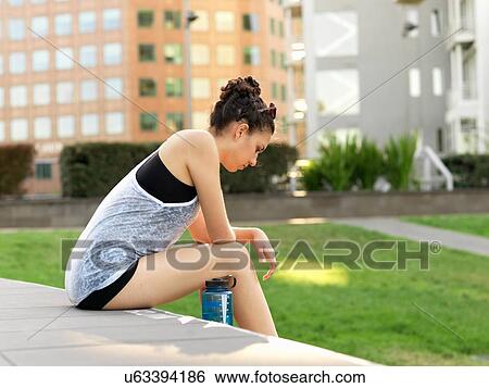 Young woman sitting in park View Large Photo Image Stock Photograph - Young woman sitting in park. Fotosearch