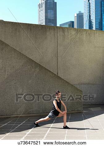 Young woman stretching in front of concrete wall, Melbourne, Victoria, Australia View Large Photo Image Stock Image - Young woman stretching in front of concrete wall, Melbourne, Victoria, Australia. Fotosearch