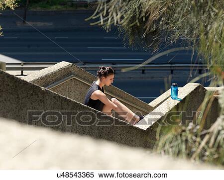 Stock Photography - Young woman stretching on steps. Fotosearch