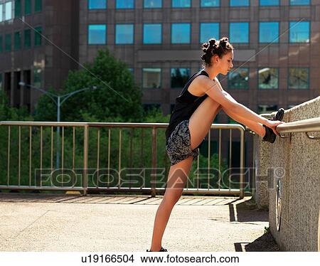 Young woman stretching on terrace, Melbourne, Victoria, Australia View Large Photo Image Picture - Young woman stretching on terrace, Melbourne, Victoria, Australia. Fotosearch