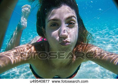 Stock Photo - Young woman swimming underwater in ocean. Fotosearch