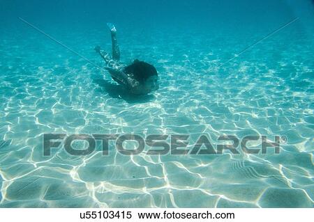 Young woman swimming underwater in ocean View Large Photo Image Stock Photography - Young woman swimming underwater in ocean. Fotosearch