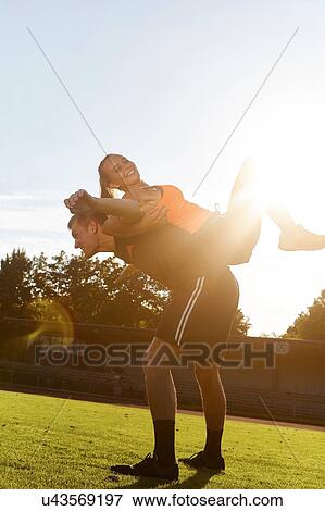 Stock Photo - Young woman training back to back with personal trainer. Fotosearch