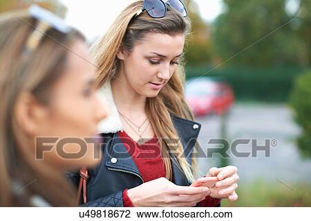Young woman using smartphone, outdoors View Large Photo Image Stock Image - Young woman using smartphone, outdoors. Fotosearch