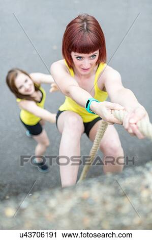 Young women climbing over wall with rope View Large Photo Image Stock Image - Young women climbing over wall with rope. Fotosearch