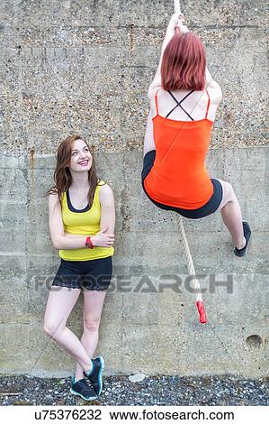 Young women climbing over wall with rope View Large Photo Image Stock Image - Young women climbing over wall with rope. Fotosearch