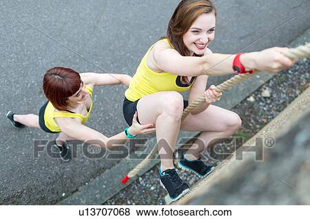 Young women climbing over wall with rope View Large Photo Image Stock Photo - Young women climbing over wall with rope. Fotosearch