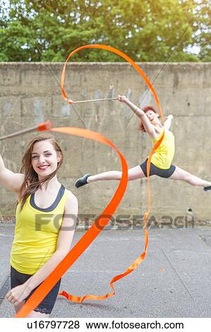 Stock Photo - Young women practising ribbon dance on court. Fotosearch