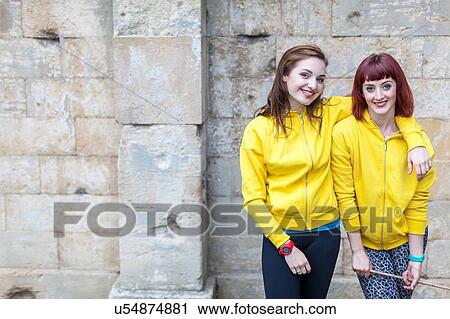 Young women smiling, stone wall in background View Large Photo Image Stock Image - Young women smiling, stone wall in background. Fotosearch
