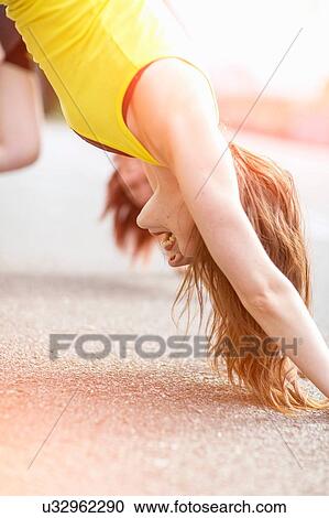 Stock Image - Young women stretching on walkway. Fotosearch