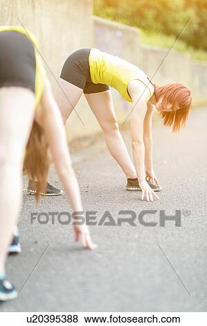 Stock Photo - Young women stretching on walkway. Fotosearch