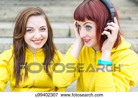 Young women with earphones on steps View Large Photo Image Stock Photo - Young women with earphones on steps. Fotosearch