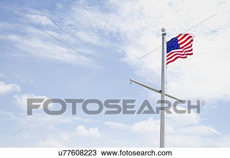 Stock Image - American flag against cloudy sky. Fotosearch