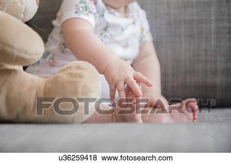 Baby girl (12-17 months) holding foot View Large Photo Image Stock Photo - Baby girl (12-17 months) holding foot. Fotosearch
