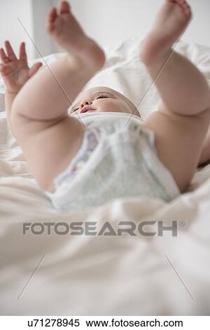 Baby girl (12-17 months) lying down with legs up View Large Photo Image Stock Photography - Baby girl (12-17 months) lying down with legs up. Fotosearch