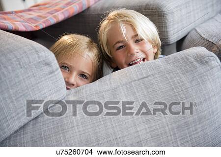 Boy (4-5) and girl (6-7) hiding behind pillows View Large Photo Image Picture - Boy (4-5) and girl (6-7) hiding behind pillows. Fotosearch