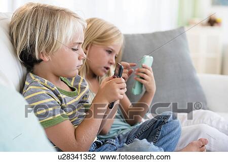 Boy (4-5) and girl (6-7) playing games on smart phones View Large Photo Image Stock Image - Boy (4-5) and girl (6-7) playing games on smart phones. Fotosearch