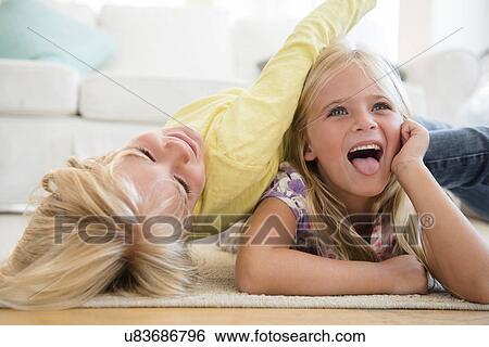 Stock Photograph - Boy (4-5) and girl (6-7) playing on floor. Fotosearch