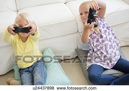 Boy (4-5) and girl (6-7) playing video game View Large Photo Image Stock Photo - Boy (4-5) and girl (6-7) playing video game. Fotosearch