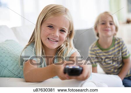 Boy (4-5) and girl (6-7) sitting on sofa View Large Photo Image Stock Image - Boy (4-5) and girl (6-7) sitting on sofa. Fotosearch