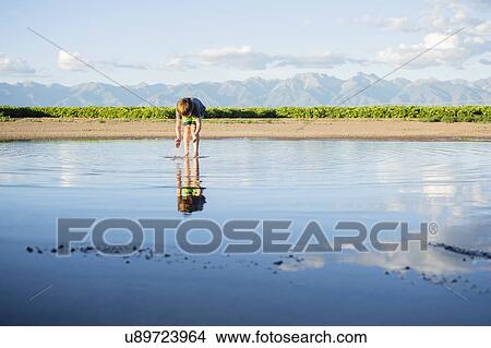 Picture - Boy (6-7) wading in water. Fotosearch