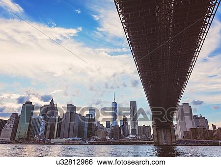 Stock Photograph - Brooklyn Bridge over Hudson River with financial district in background. Fotosearch