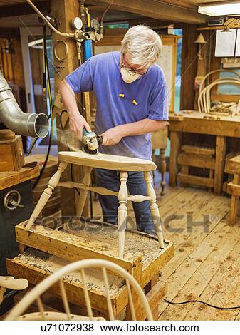 Carpenter polishing chair with sander View Large Photo Image Stock Photo - Carpenter polishing chair with sander. Fotosearch