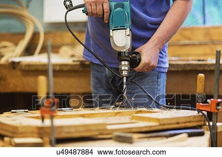 Picture - Carpenter using drill. Fotosearch