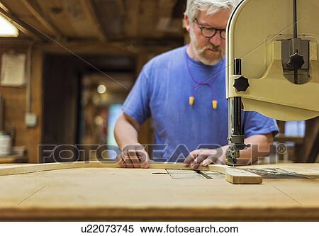 Stock Photography - Carpenter working in workshop. Fotosearch