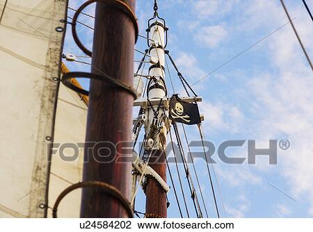 Stock Image - Close-up of sailboat's mast and pirate flag. Fotosearch