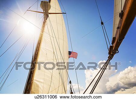 Stock Photograph - Close-up of sun shining through boat's sail. Fotosearch