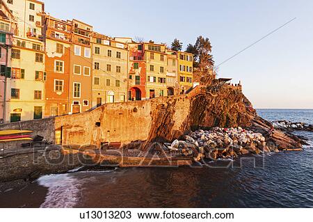 Stock Image - Coastal town at sunset. Fotosearch