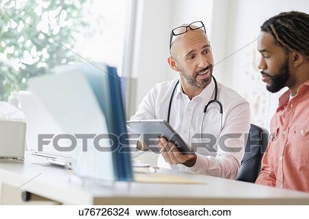 Doctor giving consultation to patient using digital tablet View Large Photo Image Picture - Doctor giving consultation to patient using digital tablet. Fotosearch