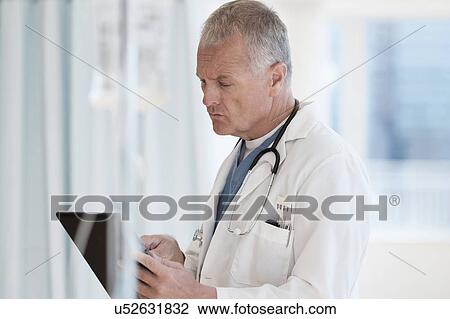 Doctor using tablet in hospital View Large Photo Image Stock Image - Doctor using tablet in hospital. Fotosearch