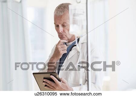 Doctor using tablet in hospital View Large Photo Image Stock Photography - Doctor using tablet in hospital. Fotosearch