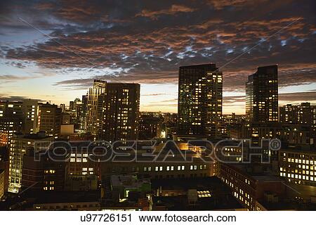 Stock Image - Dramatic sky over city at dusk. Fotosearch