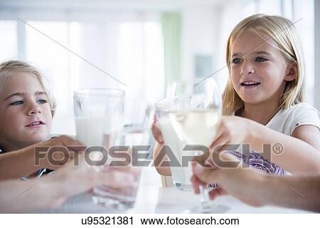 Stock Image - Family with son (4-5) and daughter (6-7) drinking refreshments. Fotosearch